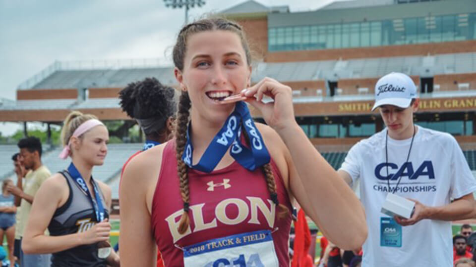 One american postgraduate student celebrating a successful race with her medal